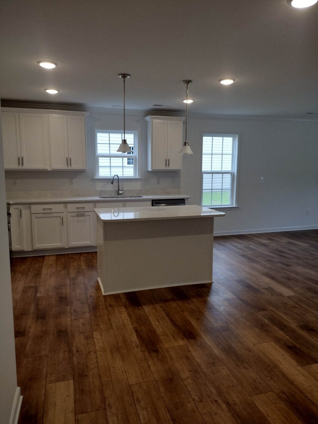 an empty kitchen with an island in the middle of it