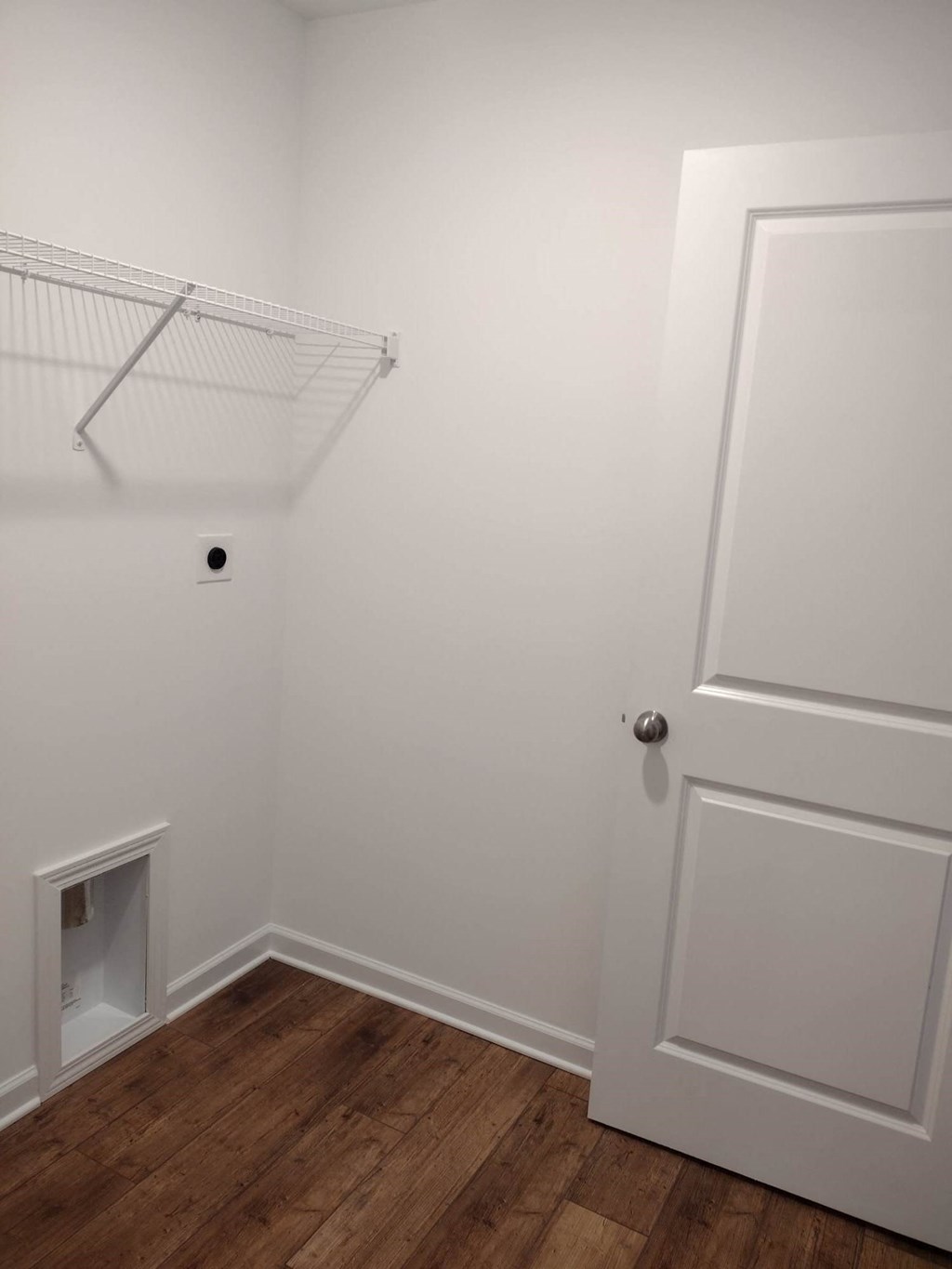 a closet in a bedroom with white walls and wooden floors