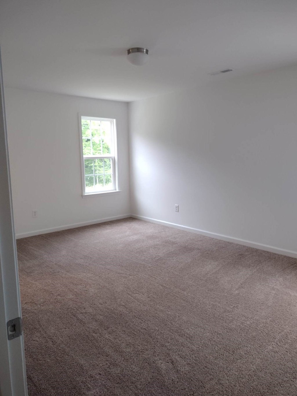 a room with a carpeted floor and a window