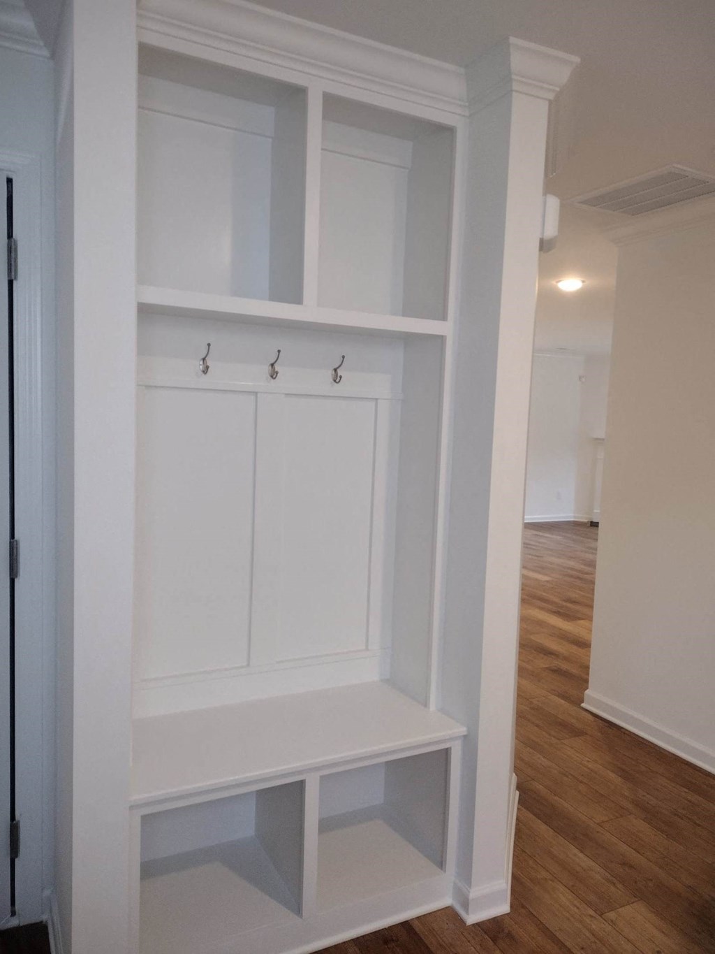 a walk in closet with white cabinets and shelves