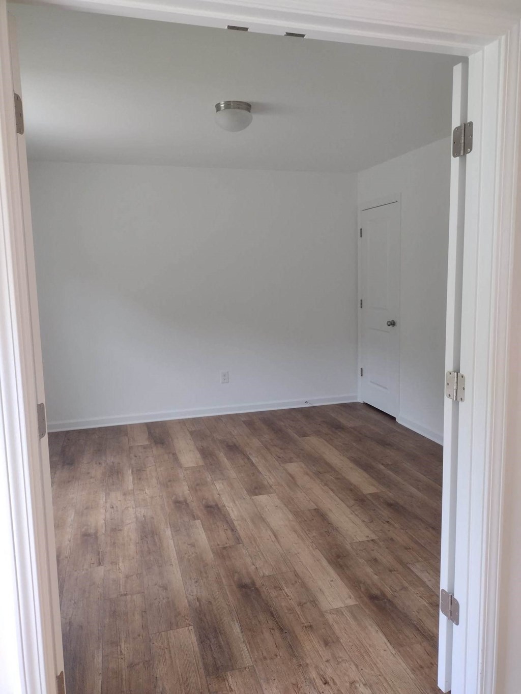 a room with a wood floor and white walls