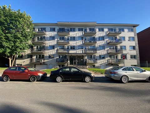 three cars parked in front of an apartment building