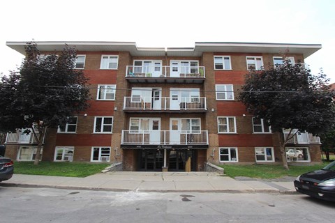 a brick apartment building with three floors and balconies