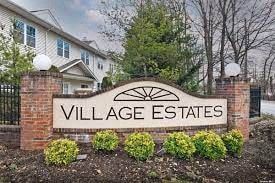 a sign for village estates in front of a house