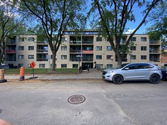 a car parked in front of an apartment building