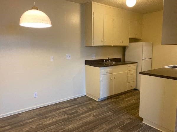 an empty kitchen with a sink and a refrigerator