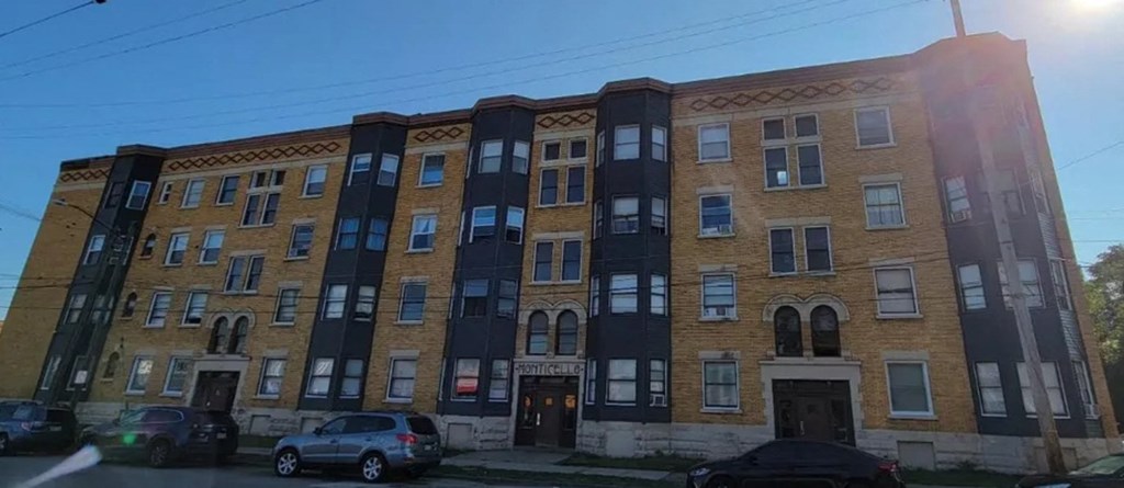 a brick building with cars parked in front of it