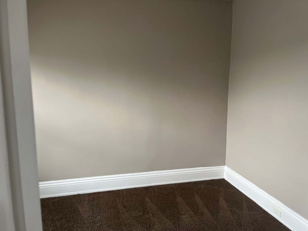 a empty room with a wooden floor and gray walls