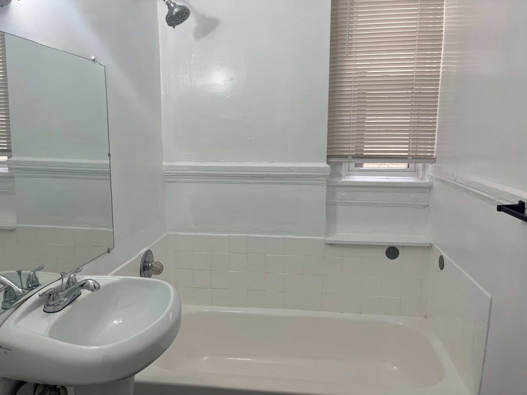 a small bathroom with a sink and a bath tub