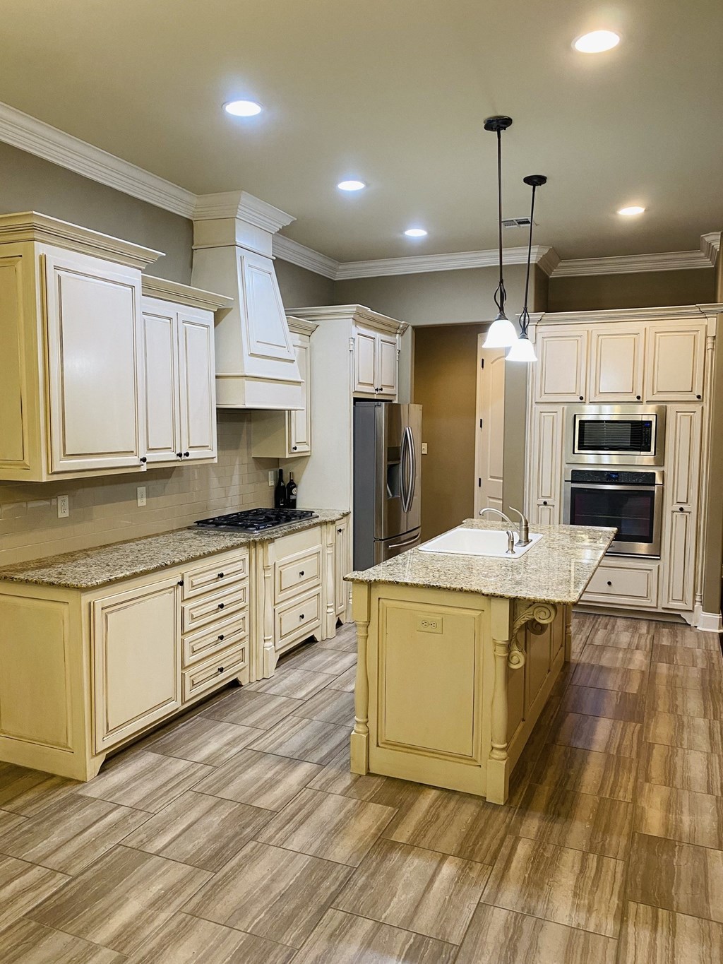 a kitchen with white cabinets and a marble counter top