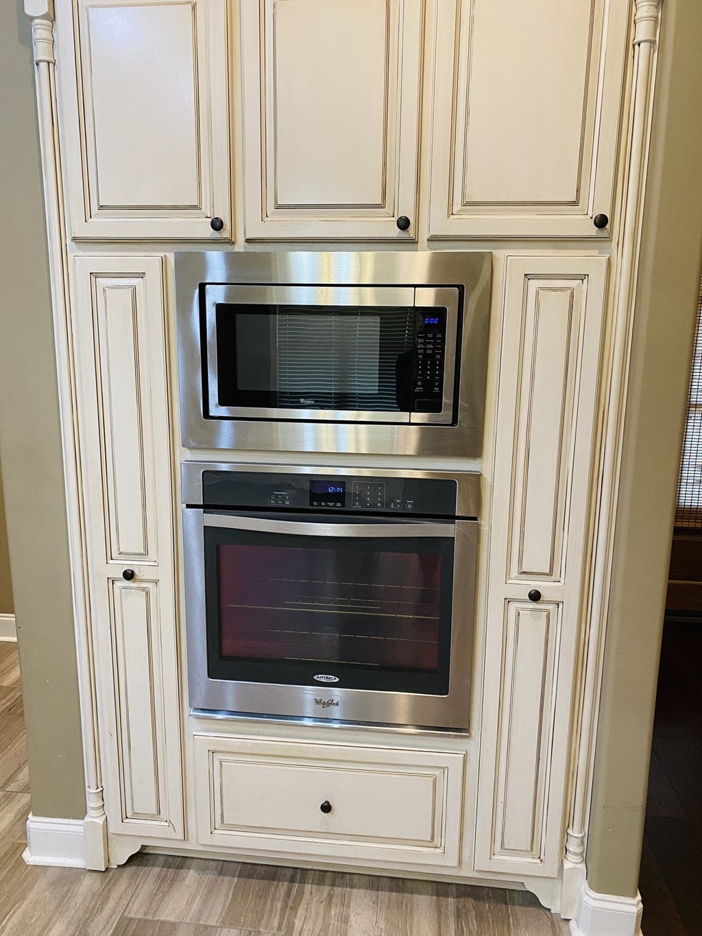 a built in microwave and oven in a white kitchen