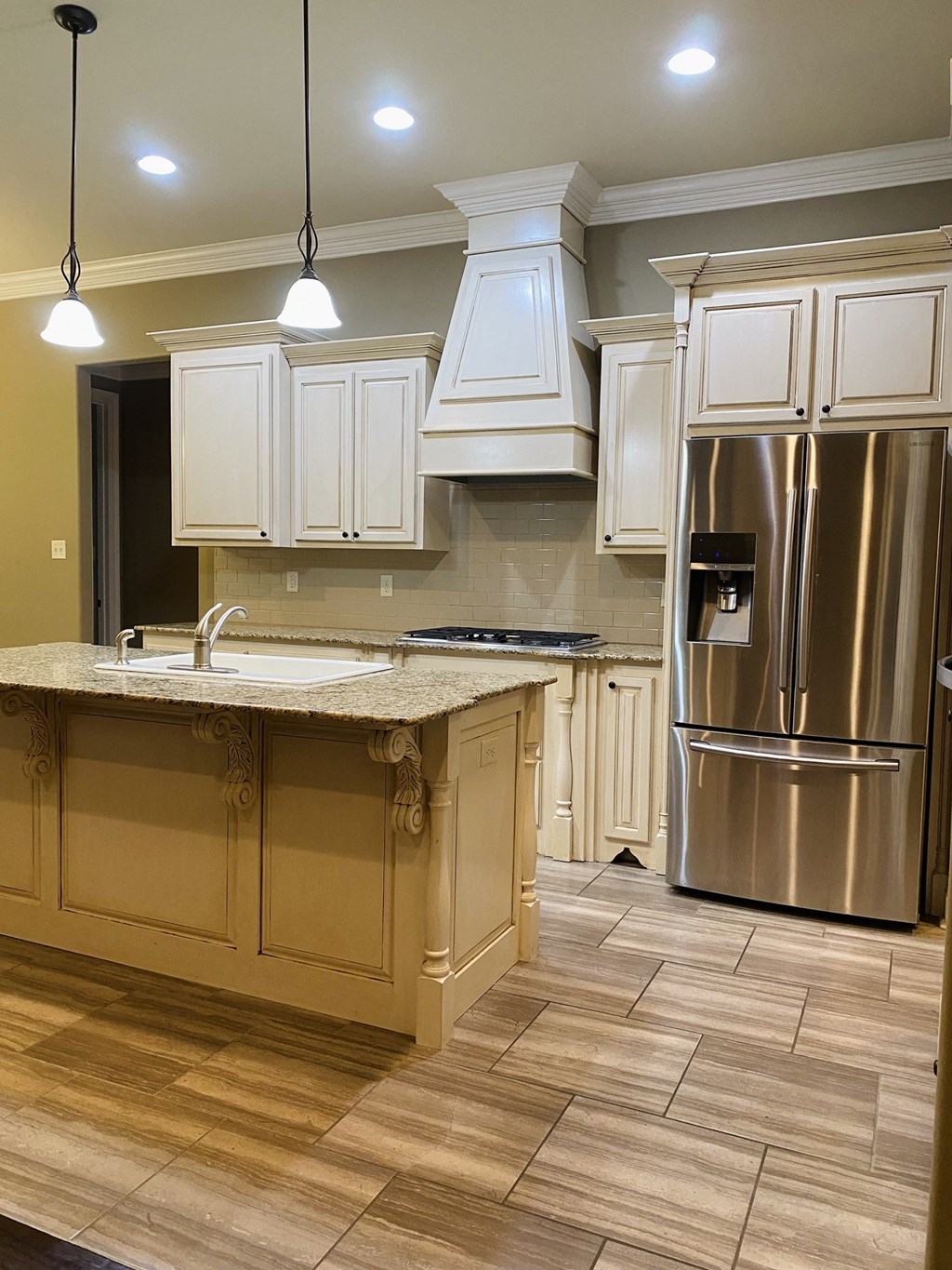a kitchen with white cabinets and a stainless steel refrigerator