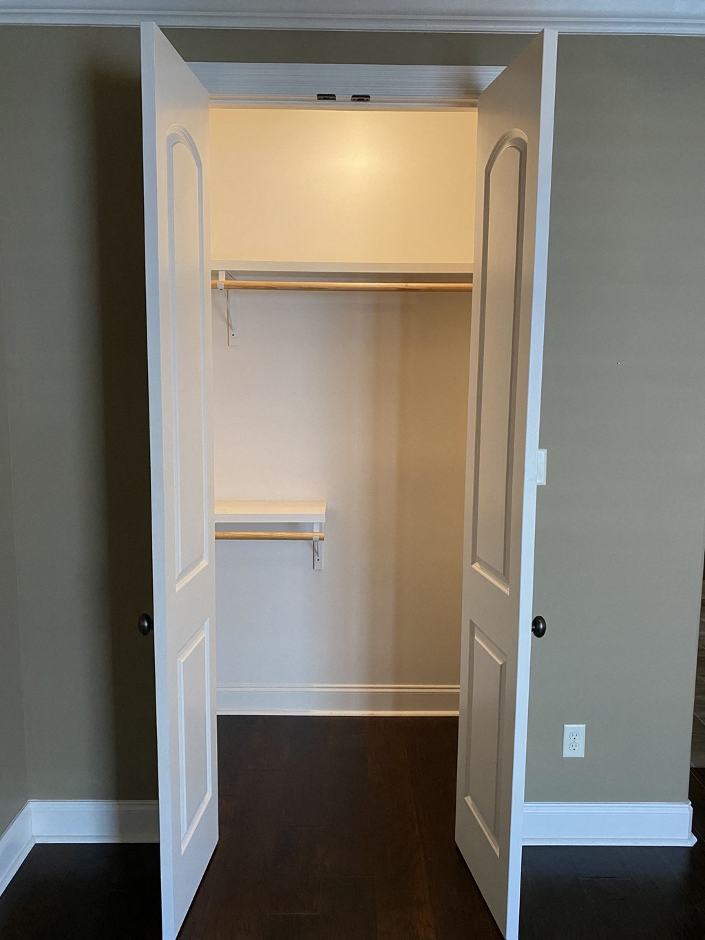 a walk in closet with a white door and a shelf
