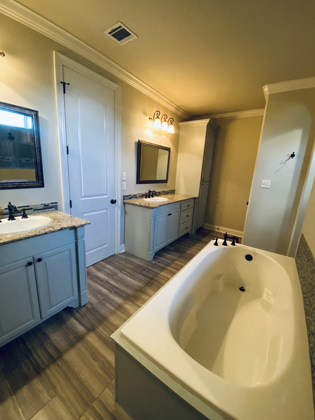a bathroom with a tub and sinks and a mirror
