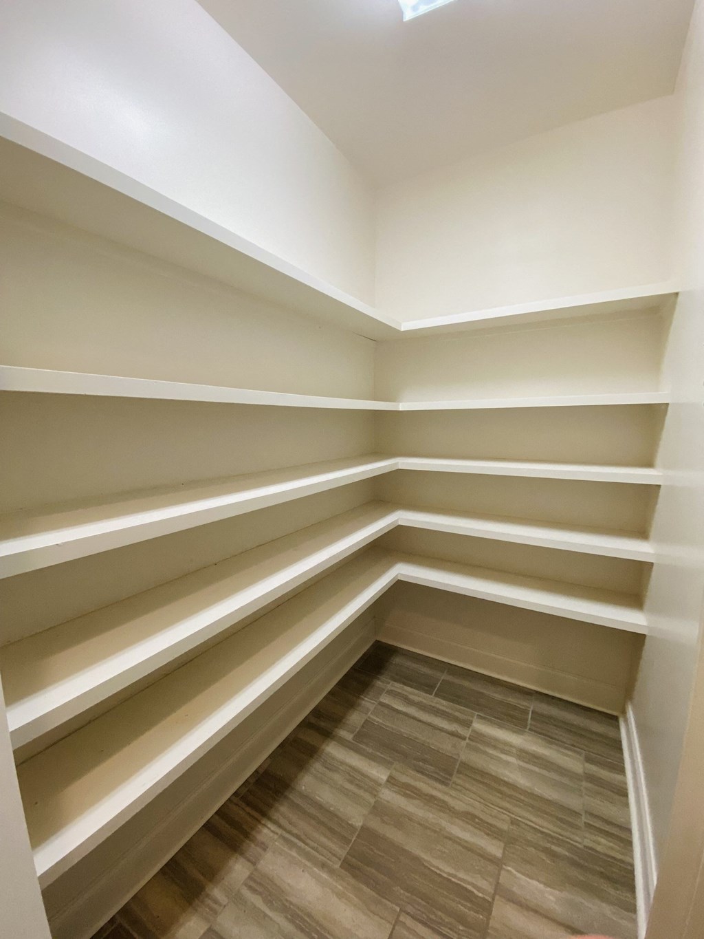 a large walk in closet with empty shelves
