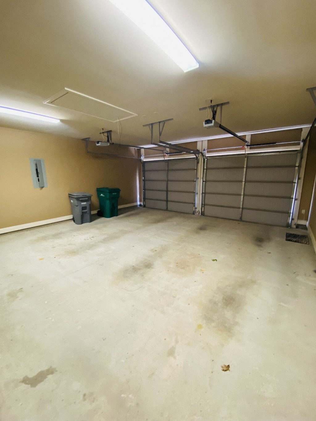 an empty garage with the doors open and the floor dirty