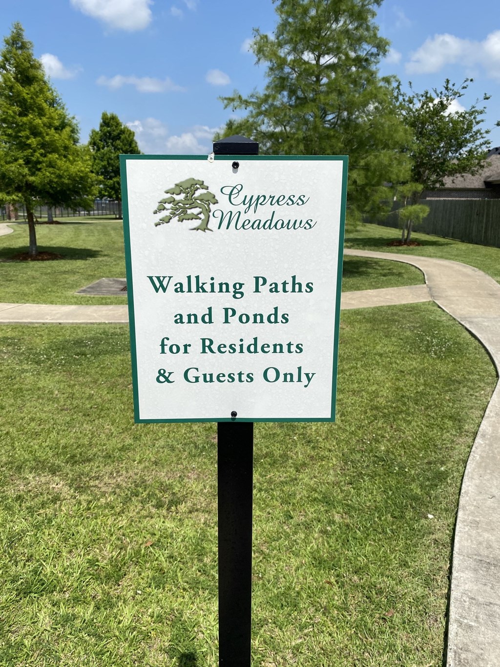 a walking paths and ponds for residents and guests only sign in a park