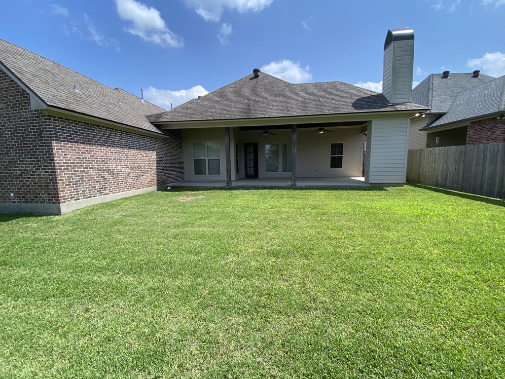 a backyard with a lawn and a brick house