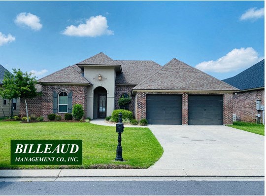 a brick house with two garage doors and a driveway