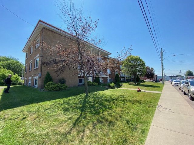 a large brick building on the side of a sidewalk