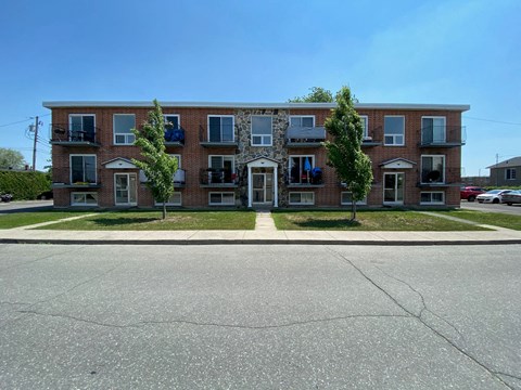 a red brick apartment building on the side of a street