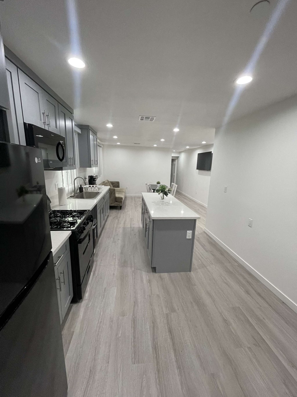 an empty kitchen with white cabinets and stainless steel appliances