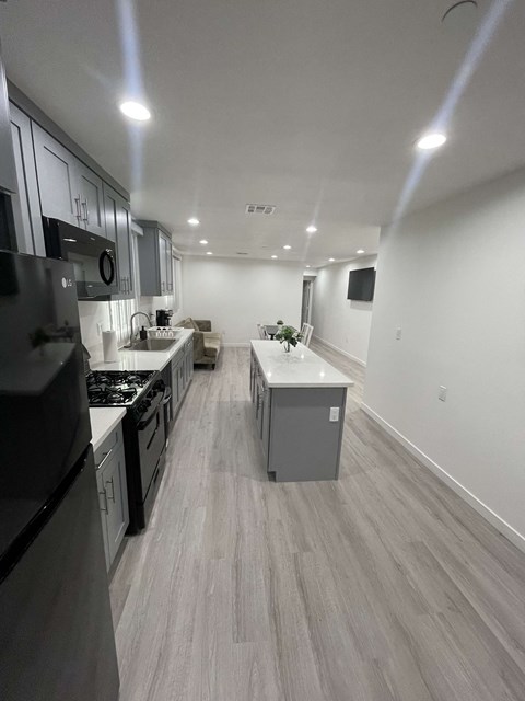 an empty kitchen with white cabinets and stainless steel appliances