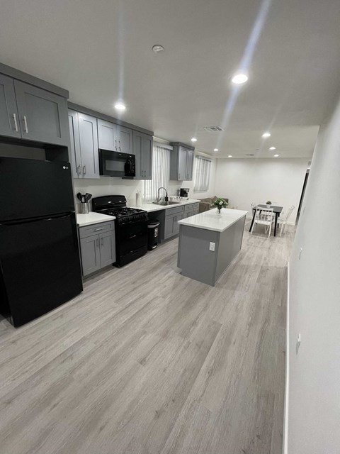 an open kitchen with black appliances and white cabinets