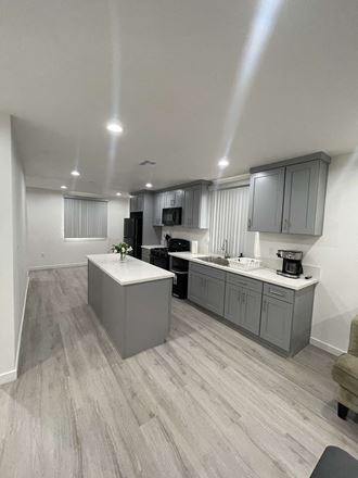 a renovated kitchen with gray cabinets and white counter tops