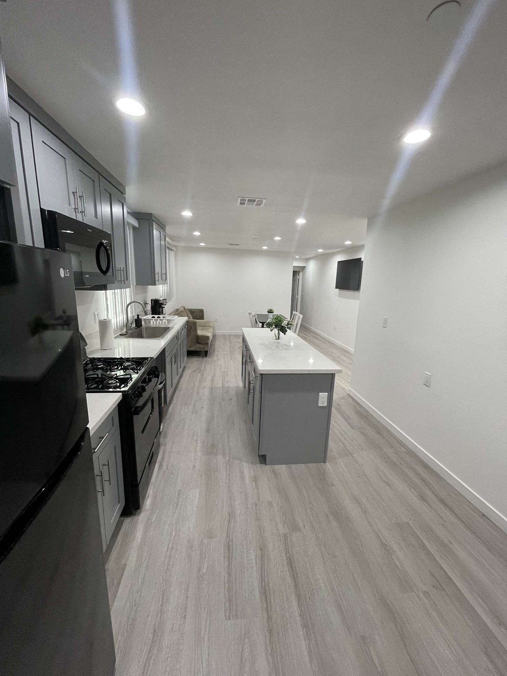 an empty kitchen with white cabinets and stainless steel appliances