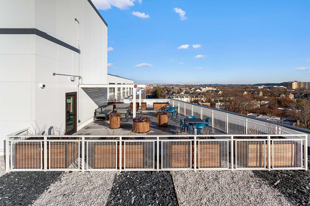 the deck of a building with a table and chairs on it