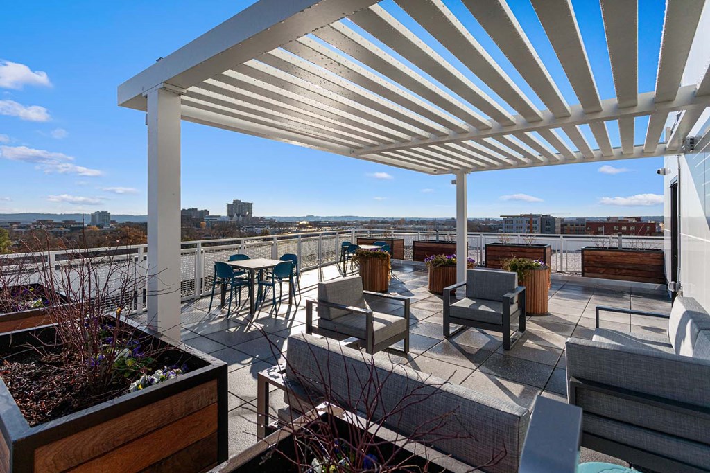 a roof terrace with patio furniture and a view of the city