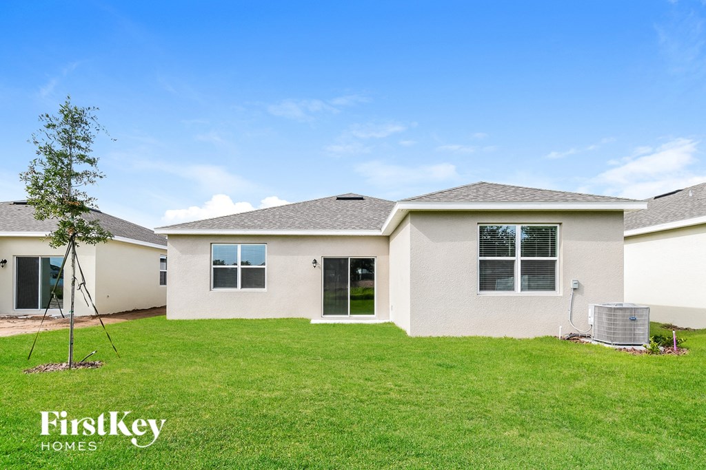 a white house with a lawn and a blue sky