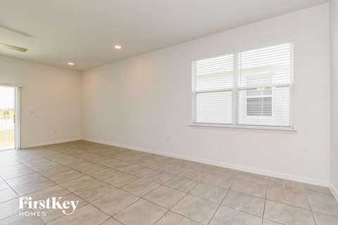 A spacious room with a window and tiled floor.