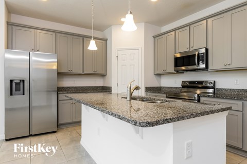 A kitchen with granite countertops and stainless steel appliances.