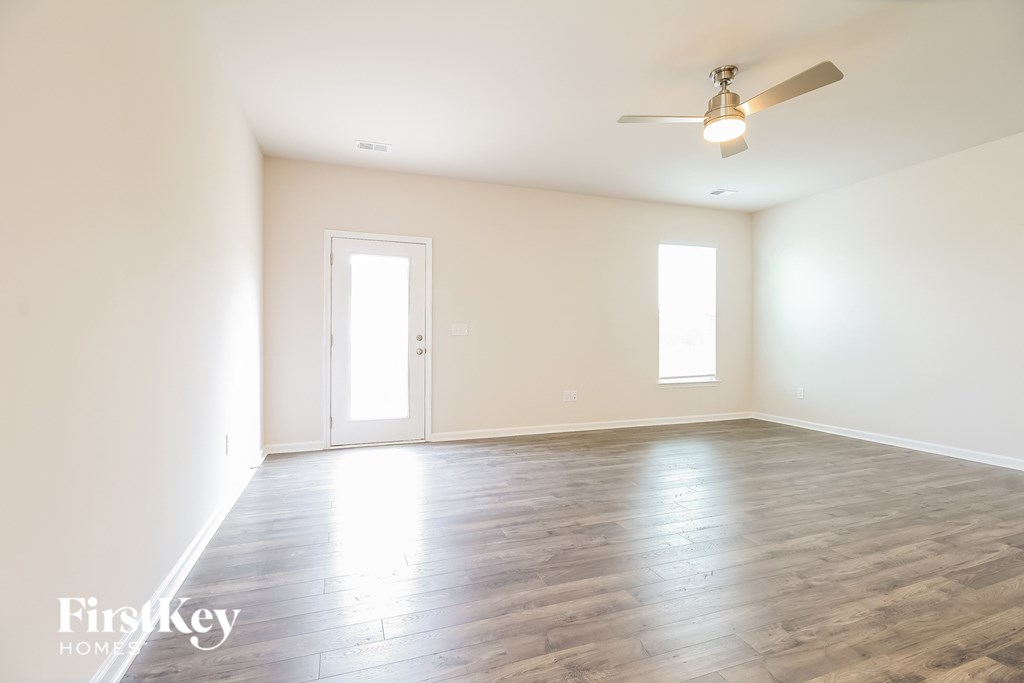 an empty living room with white walls and wood floors