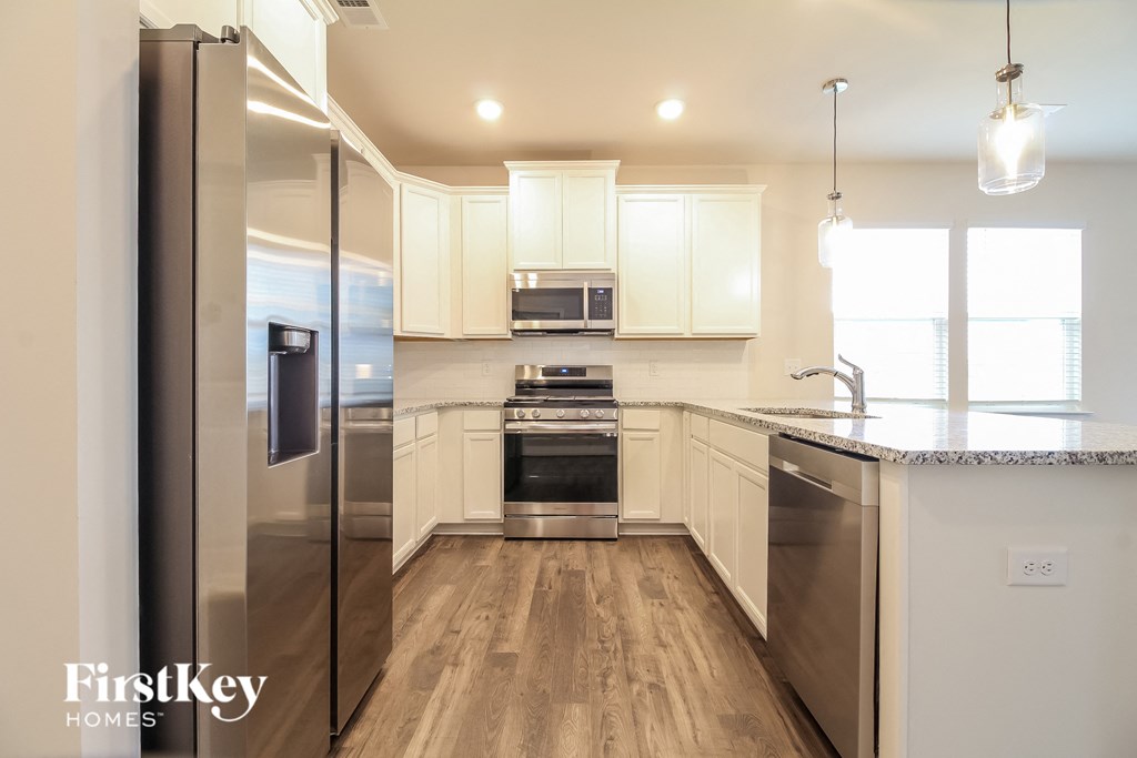 a kitchen with white cabinets and stainless steel appliances