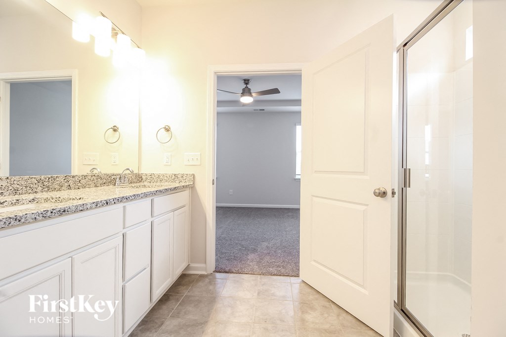 a bathroom with a sink and a shower and a closet