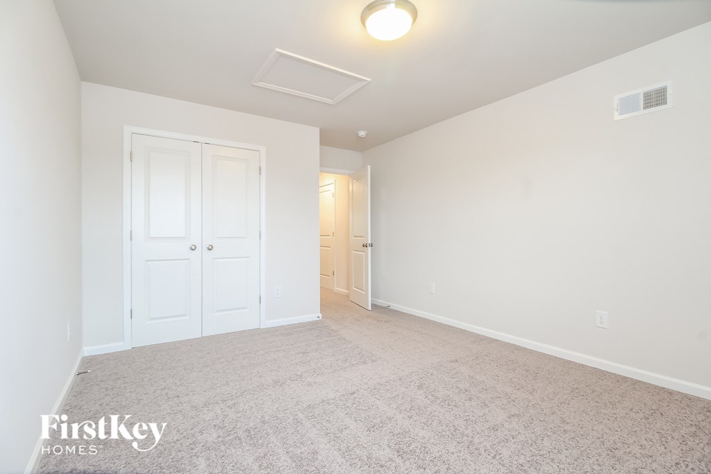 a spacious living room with a carpeted floor and a white door to a hallway
