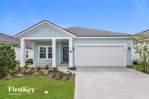 a blue house with a driveway and a garage door