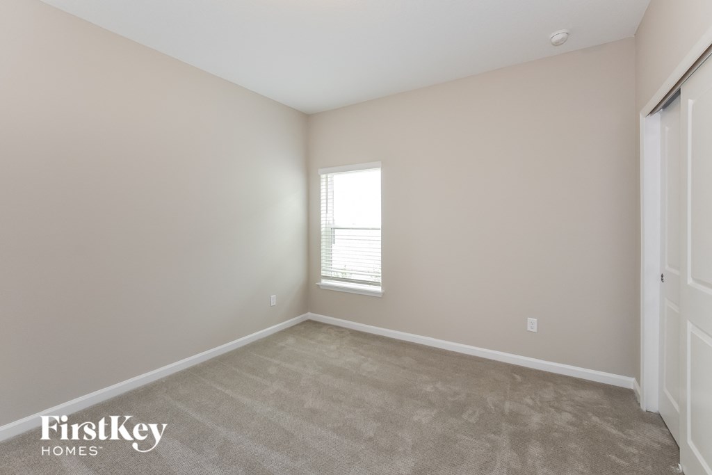 a bedroom with a carpeted floor and a window