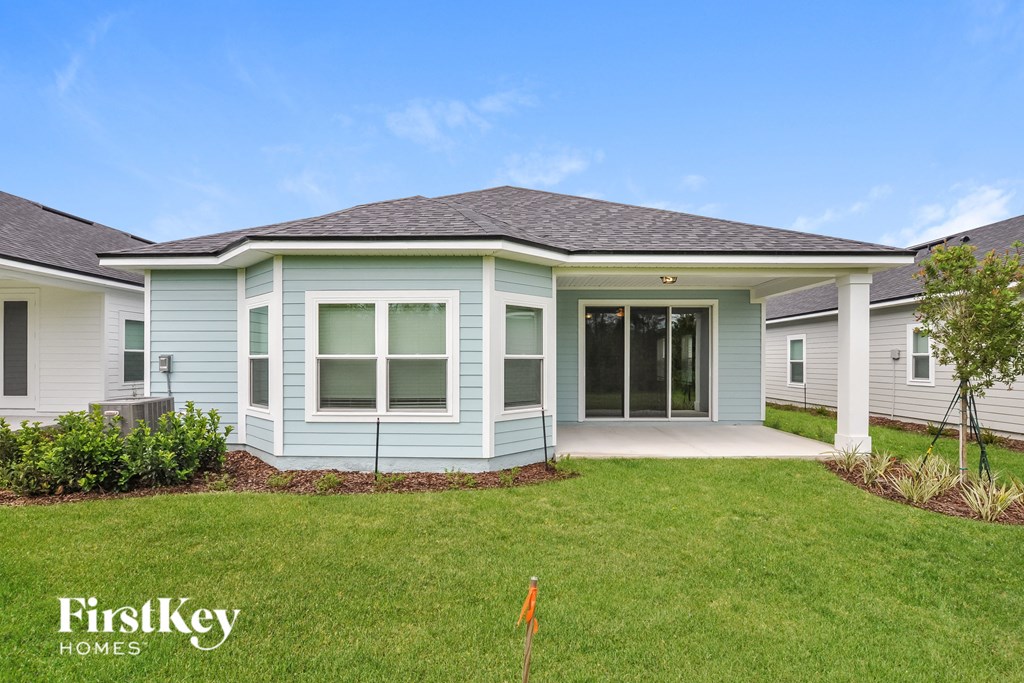 a blue house with a lawn and a driveway
