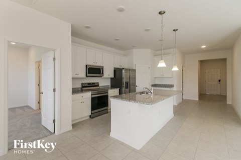 A kitchen with a white island and stainless steel appliances.