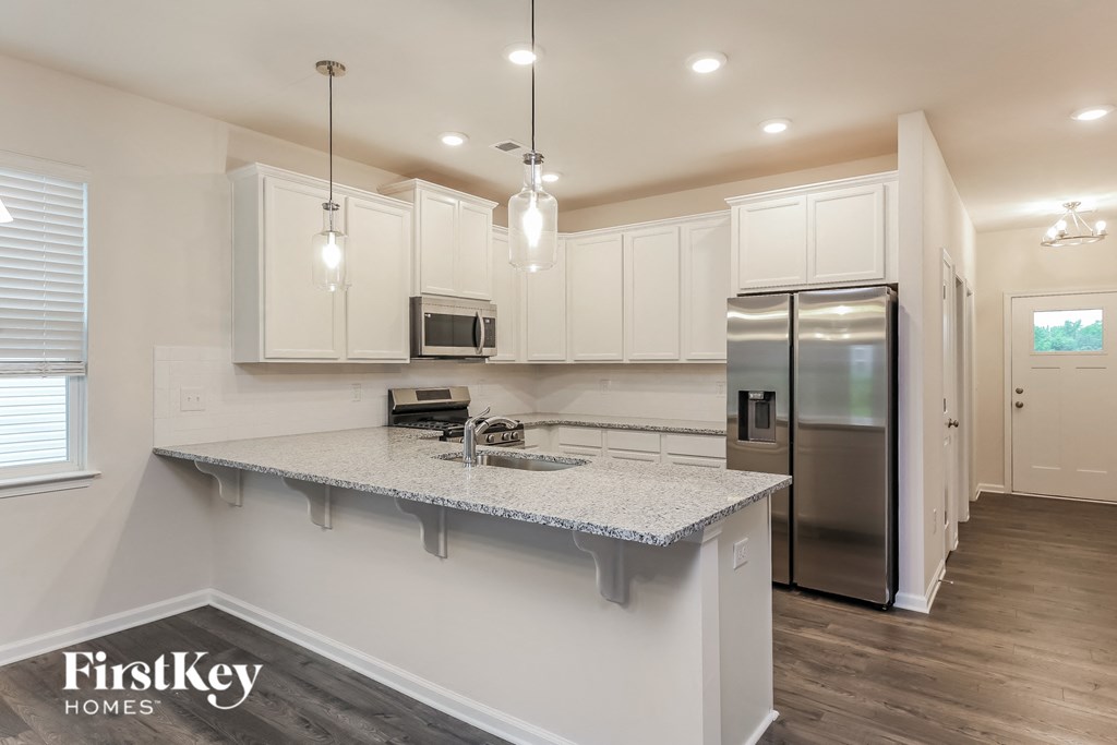 a kitchen with white cabinets and a granite counter top