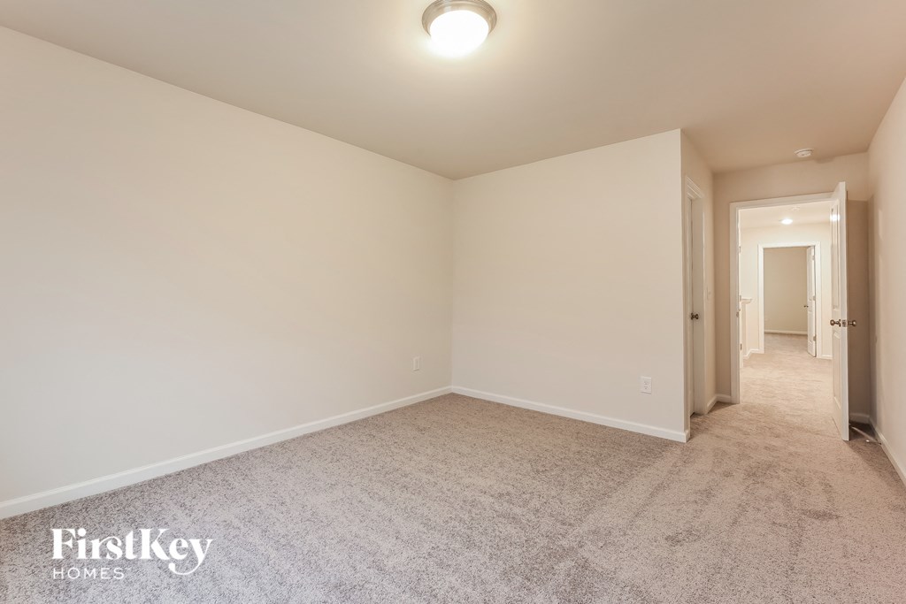 a spacious living room with carpet and white walls