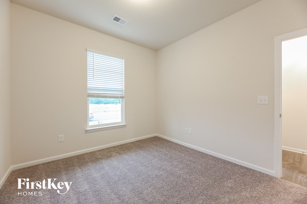 a bedroom with a carpeted floor and a window