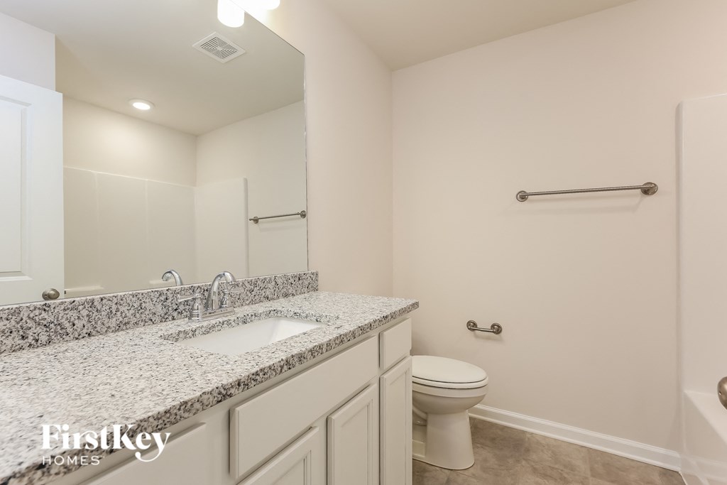 a bathroom with a toilet and a sink and a mirror