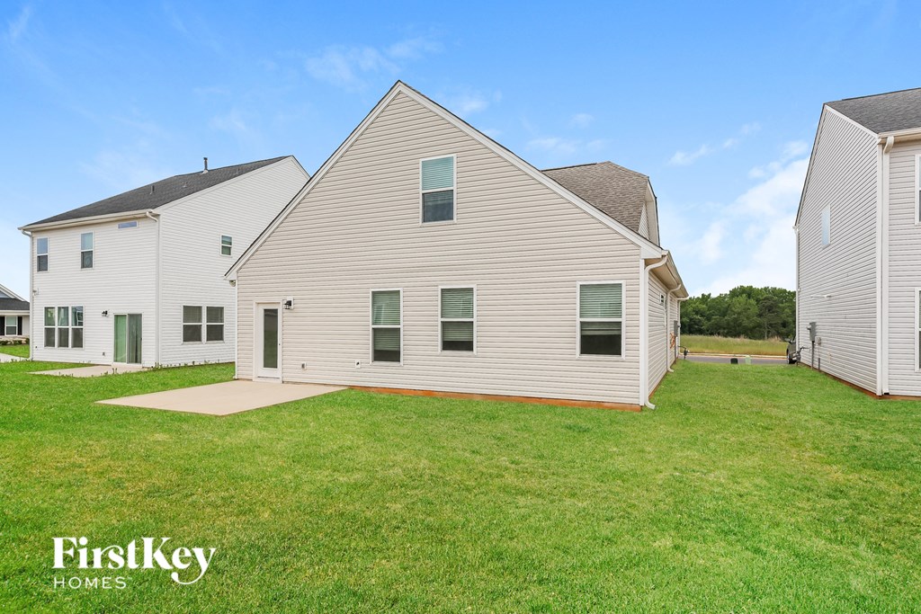 a white house with white siding and a green lawn