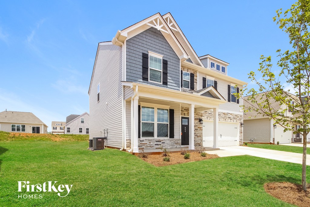 A modern house with a grey exterior and a black door.