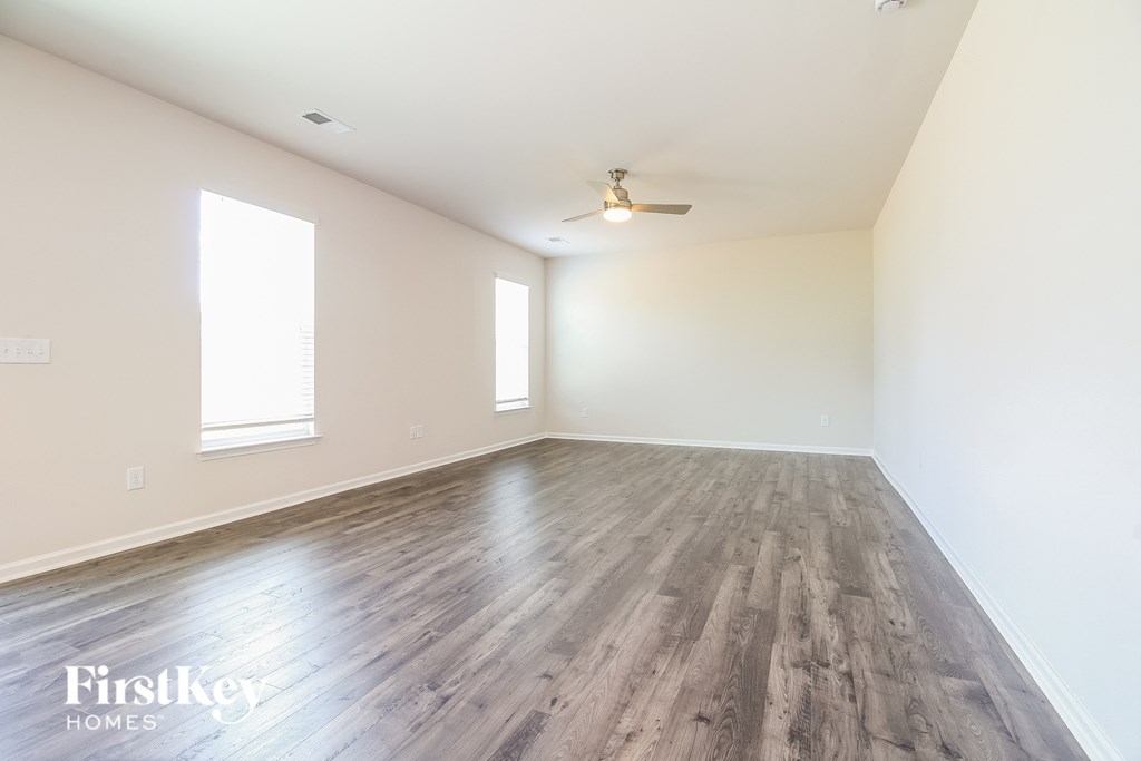 A room with wooden flooring and a ceiling fan.